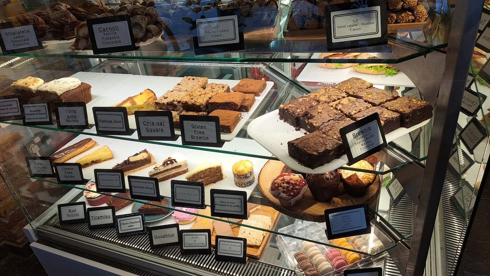 Glass display cabinet at Café Torelli packed with cakes, brownies and pastries